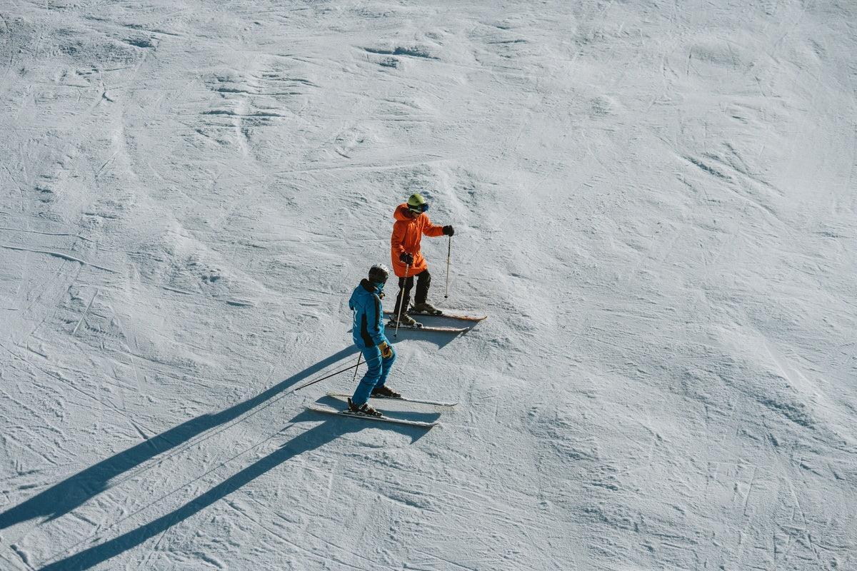 Skilehrer erklärt einem Schüler die Technik auf einer Piste in Baqueira