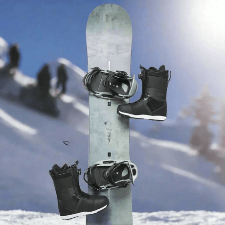Tabla de snowboard gris con fijaciones y dos botas de snowboard negras