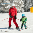 Kind lernt mit seinem Skilehrer Ski fahren
