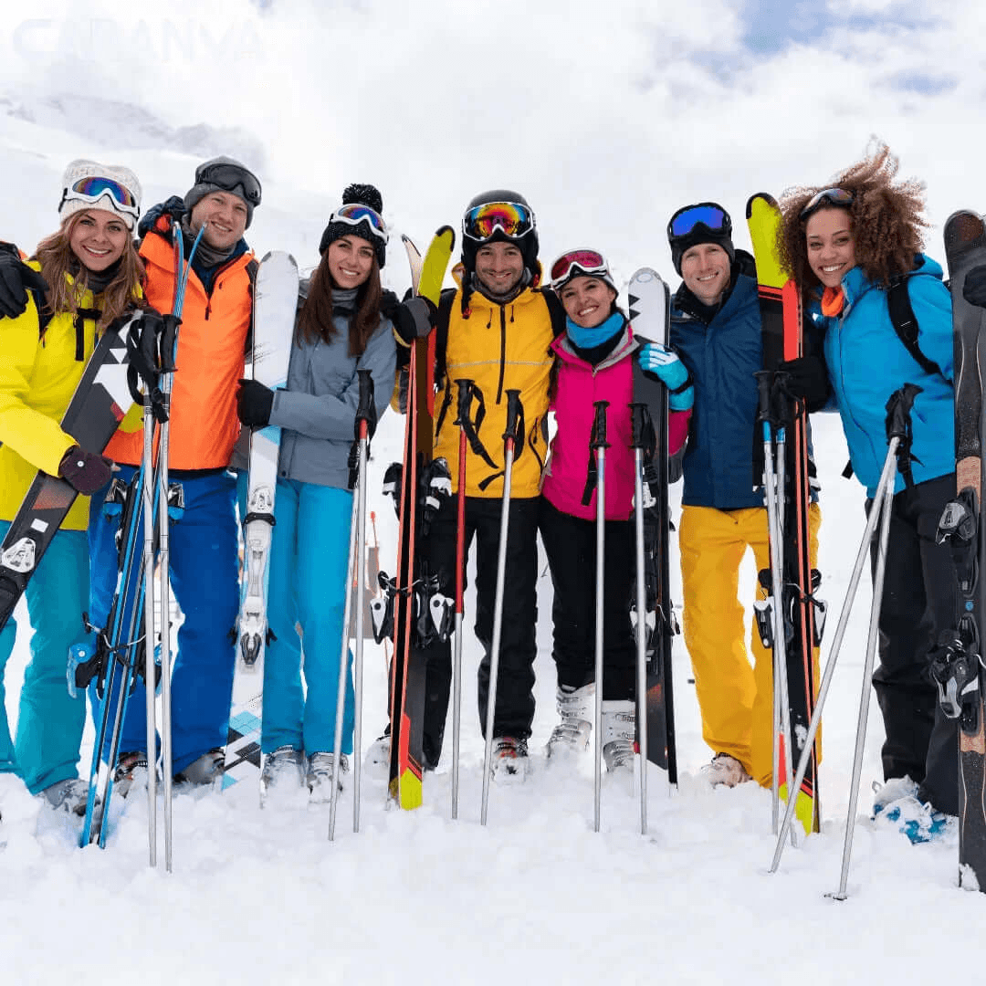 Gruppe von Freunden, die lächelnd mit Ski und Stöcken im Schnee stehen